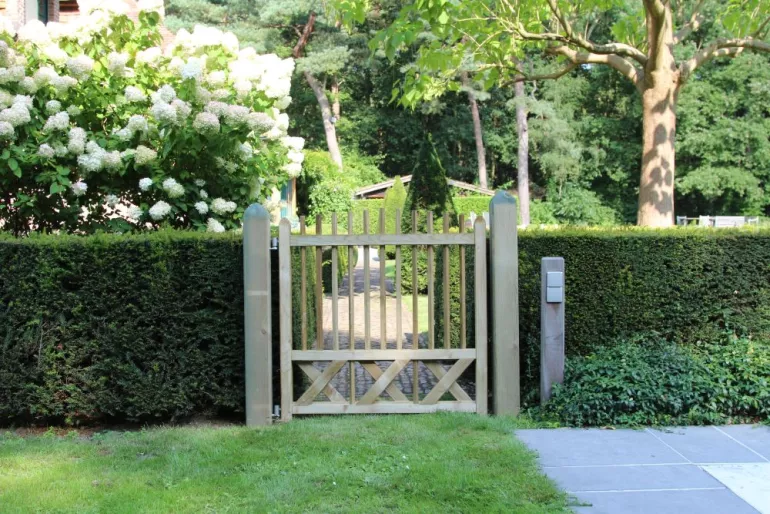 Cottage houten poort met smalle verticale palen in een tuin