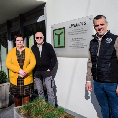 3 mensen voor een wit gebouw