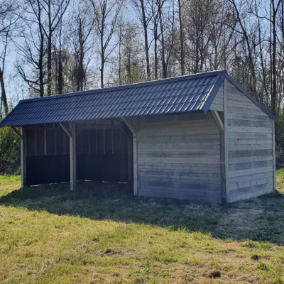 Een dubbel houten schuilstal voor dieren met een plek voor opslag